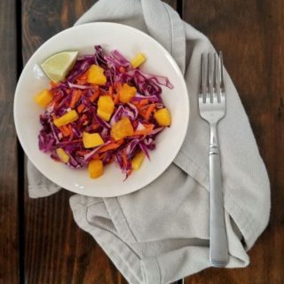 cabbage and mango slaw in bowl with fork