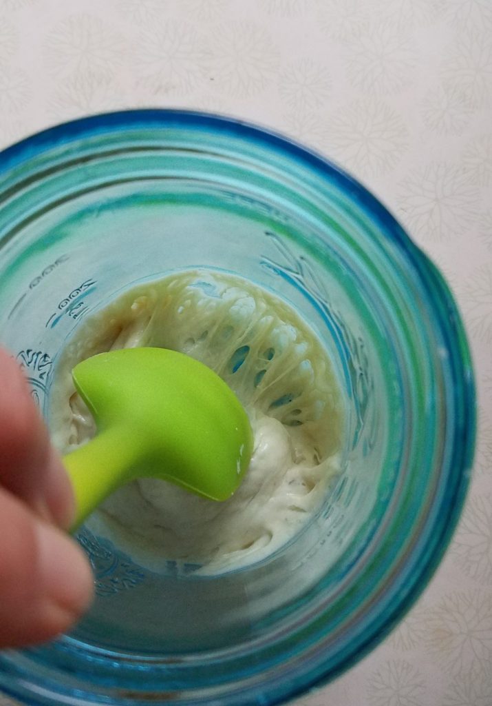 Small sourdough starter in blue jar that is very active