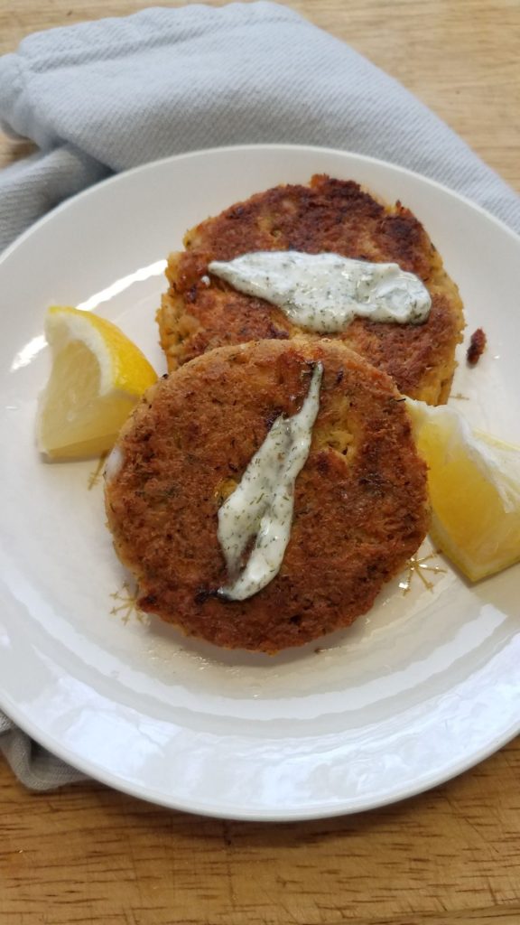 salmon cakes and lemon wedges on white plate