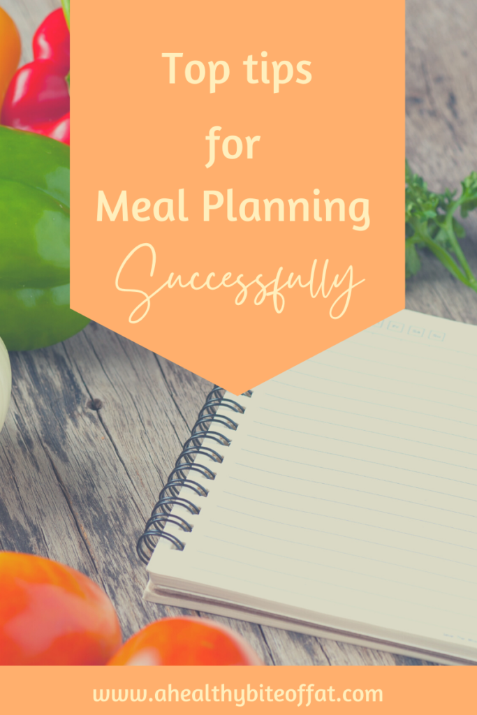 top tips for meal planning banner over notebook and vegatables