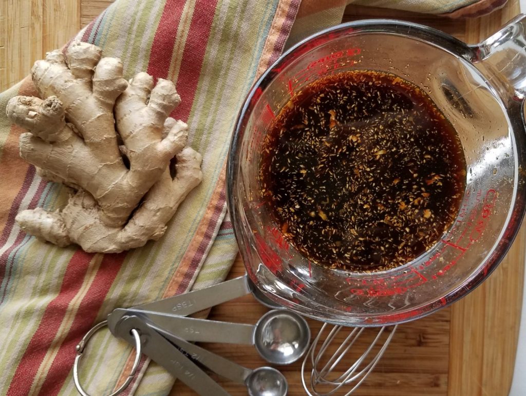 Sauce for Asian Style Chicken in measuring cup with ginger and measuring spoons in background