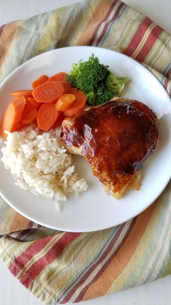 Asian Style Chicken on white plate with broccoli, carrots, and white rice