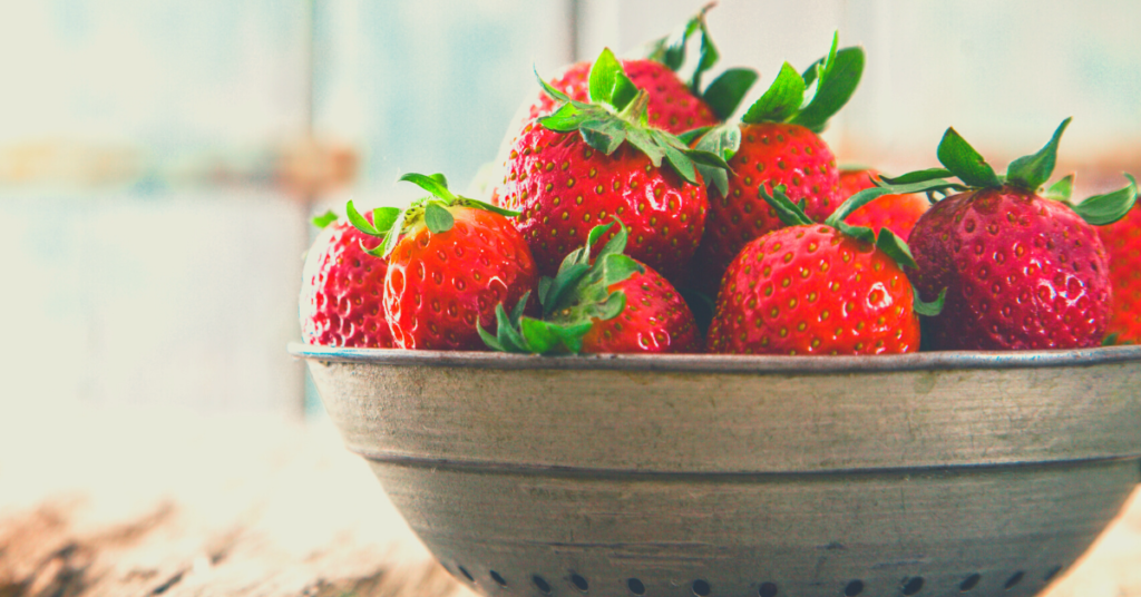 ripe strawberries in metal colander