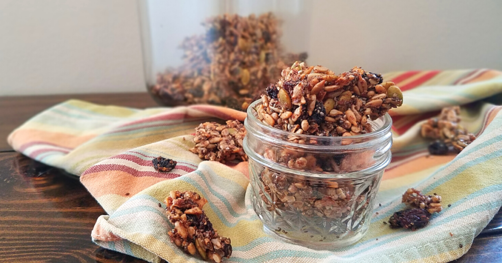 Nut-free granola in small mason jar on stripped towel