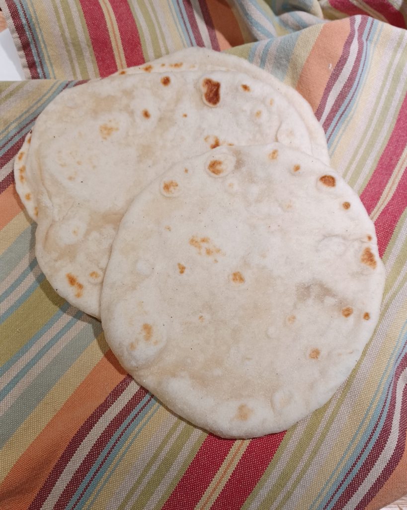 Sourdough tortilla stacked on stripped towel