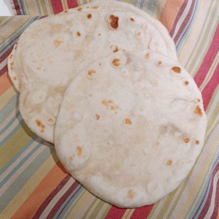 Sourdough tortilla stacked on stripped towel