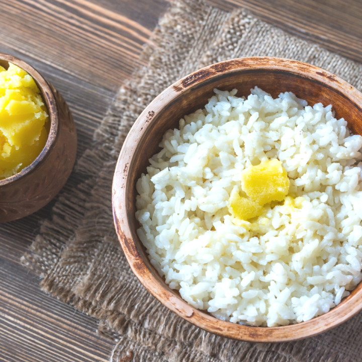 white rice with butter in brown bowl