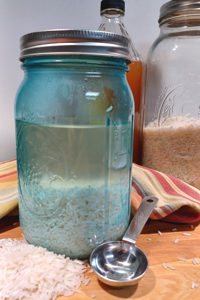 white rice soaking in water in blue mason jar