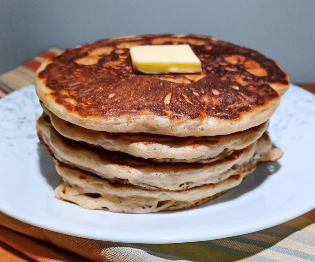 Sourdough Pancakes stacked on plate with butter