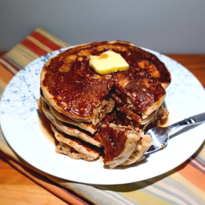 stack of sourdough pancakes with some on a fork laying on the plate