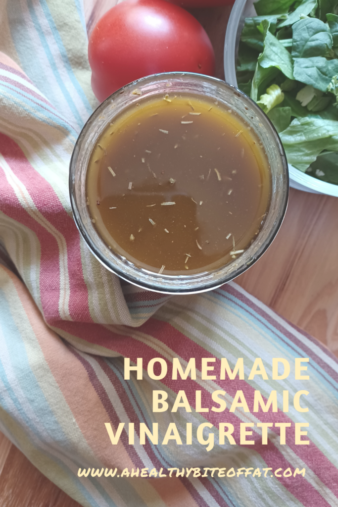 Balsamic vinaigrette in jar with salad and tomato