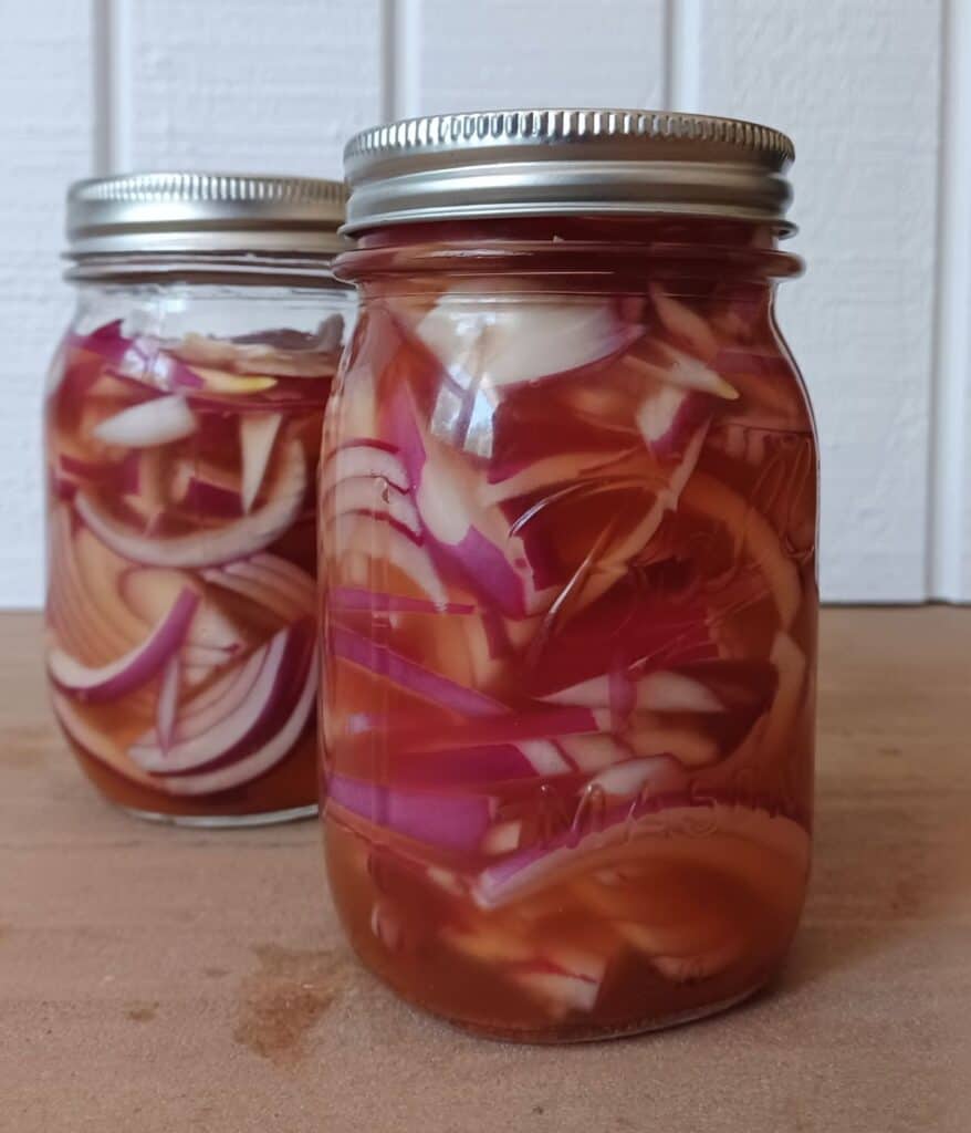 Red onions marinating in mason jars 